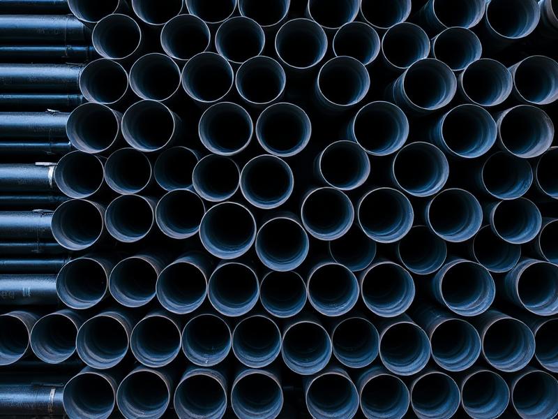 Bundle of black carbon steel pipes viewed end-on — Steel Pipes supplied by Qutbi Trading W.L.L